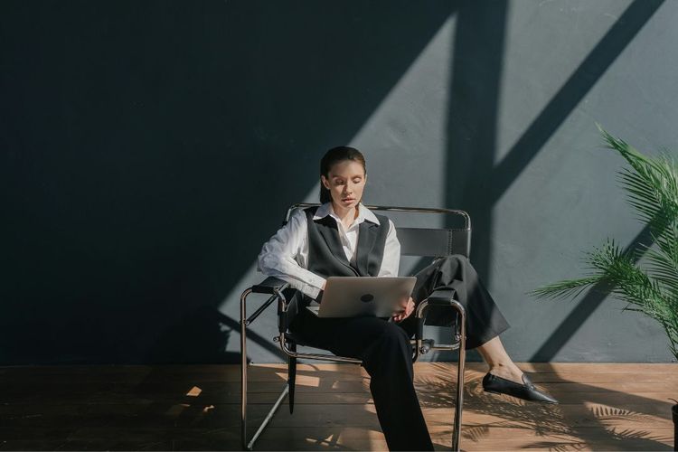 Mulher sentada e mexendo no computador (Foto de Mikhail Nilov para Pexels)